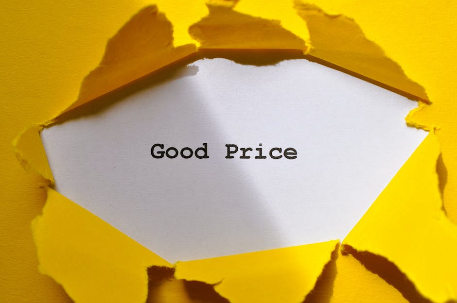 A piece of bright yellow paper is torn open, revealing a white inner layer with the message 'Good Price' printed in black text. The torn edges are irregular and jagged, exposing the inner surface and contrasting with the smooth, clean appearance of the visible message. The background is also yellow, matching the torn outer layer, and the image suggests a concept of revealing value or affordability, which could be associated with house removals, packing, and moving services provided by Eltham Man and Van, especially in the context of avoiding hidden costs during home relocation or furniture transport.